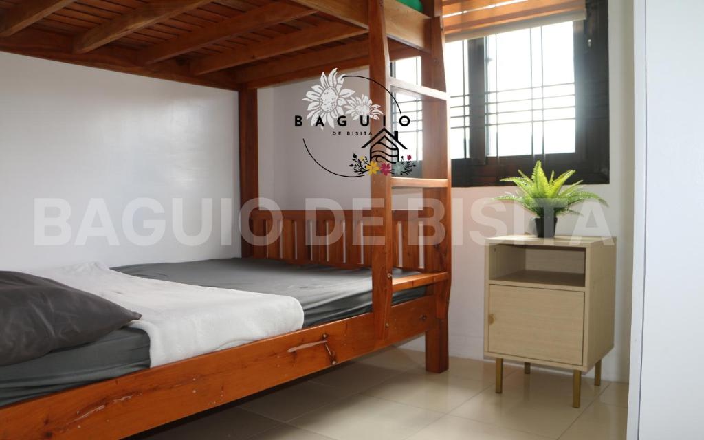 um quarto com um beliche de madeira e uma mesa em Baguio De Bisita em Baguio