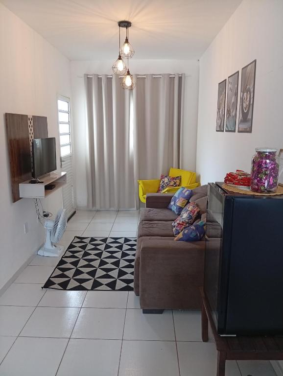 a living room with a couch and a tv at Casa de férias Pôr do Sol in Presidente Epitácio
