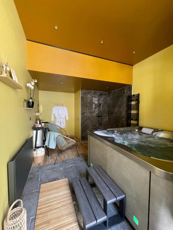a bathroom with a tub with a bench in it at Maison Côté Halle La chambre de l'Artiste in Saint-Flour
