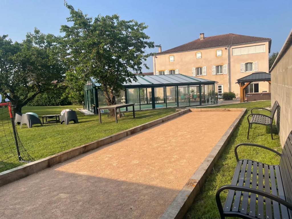 a park with benches in front of a building at Demeure de Charme de la Gravière in Mably