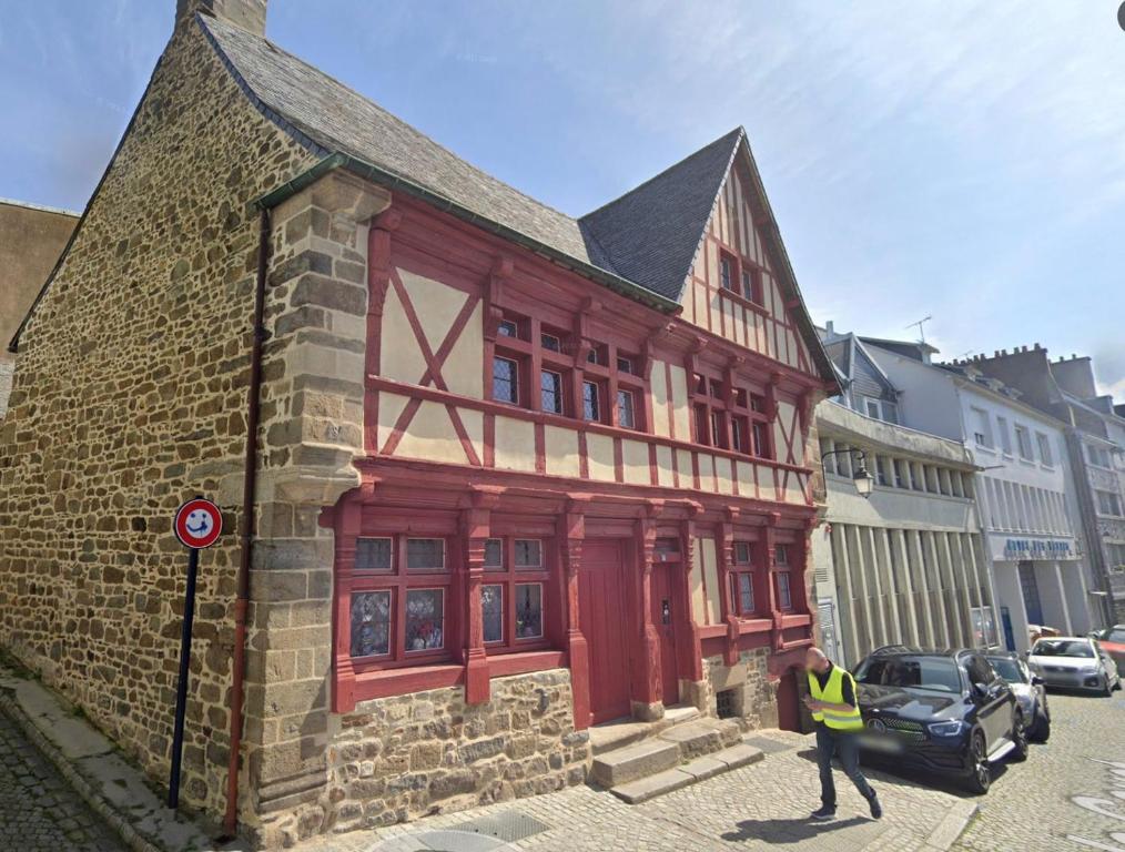 un homme marchant devant un bâtiment en briques dans l'établissement LE GOUET - Maison de la Barrière, à Saint-Brieuc