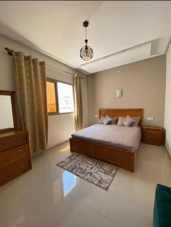 a bedroom with a large bed and a window at Downtown apartment in Agadir