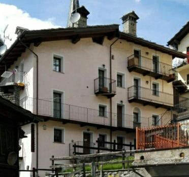 un gran edificio blanco con balcones en la parte superior. en Appartamenti Paquier, en Valtournenche