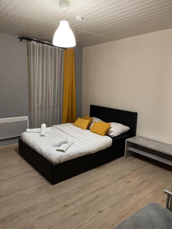 une chambre avec un grand lit avec des oreillers jaunes dans l'établissement Appartement Brest proximité gare et centre, à Brest
