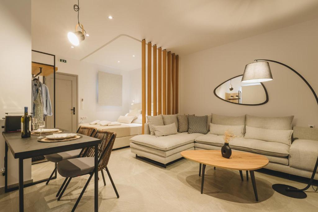 een woonkamer met een bank en een tafel bij Capital Suites Skopelos in Neo Klima