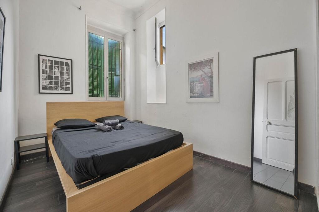 une chambre avec un lit et un grand miroir dans l'établissement Nice et confortable 2 pièces cozy, à Nice