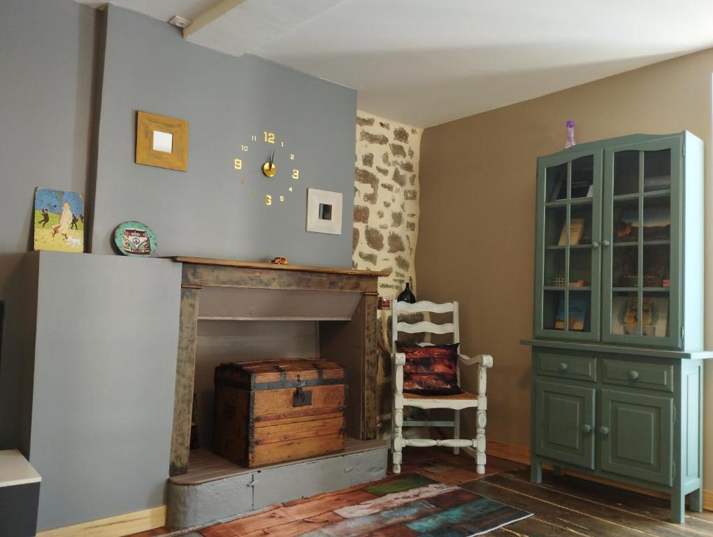 a living room with a fireplace and a green cabinet at Maison cévenole Alzon in Alzon