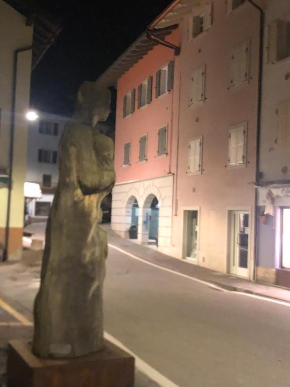 a statue in the middle of a street at night at Moderno appartamento e ampio garage in centro in Folgaria