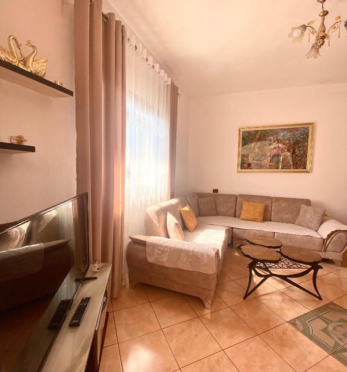 a living room with a couch and a tv at At-Salaj1 in Vlorë