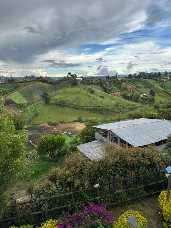 a house in a field with a solar roof at Casa en Marinilla cerca a guatape y el peñol in Marinilla