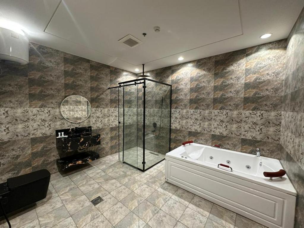 een badkamer met een bad en een douche bij الجوهرة بارك 1 in Riyad