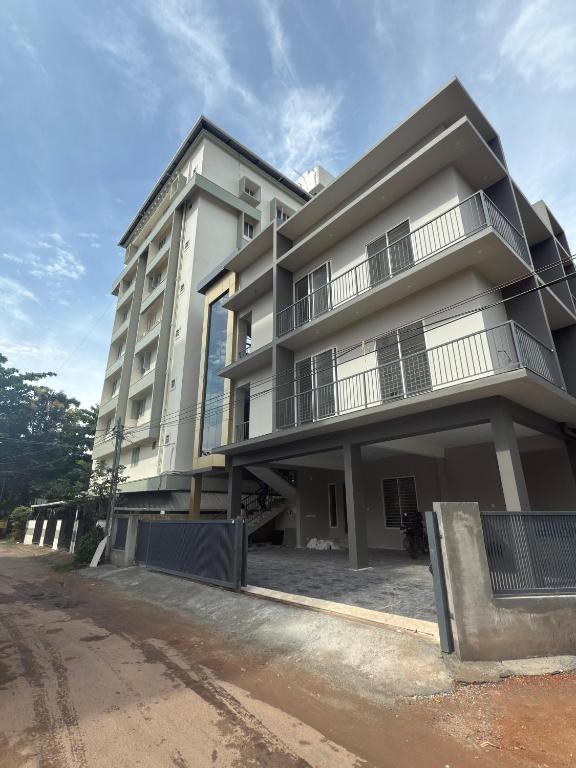 卡卡纳德The Nexus Hotel Kakkanad的街边的一栋白色大楼