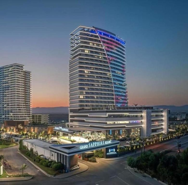 a tall building with lights on it in a city at GRAND SAPPHIRE HOTEL CASINO and RESIDENTS 1 Bedroom Suit with Superior Sea View and Free Internet in Áyios Yeórgios