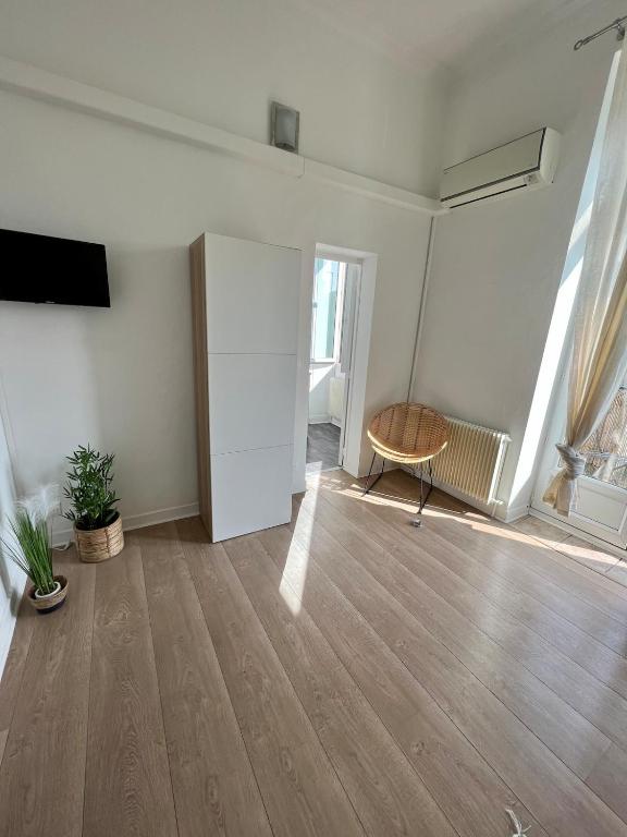 un salon vide avec une chaise et une télévision dans l'établissement Beautiful T1 Bordeaux apartment with balcony, à Talence