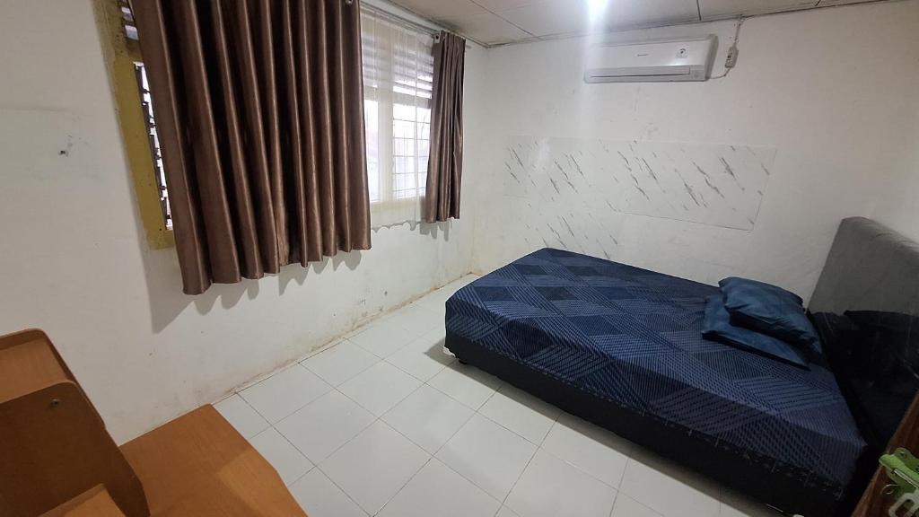 a bedroom with a bed in a room with a window at 88HappyHomestay in Luwuk