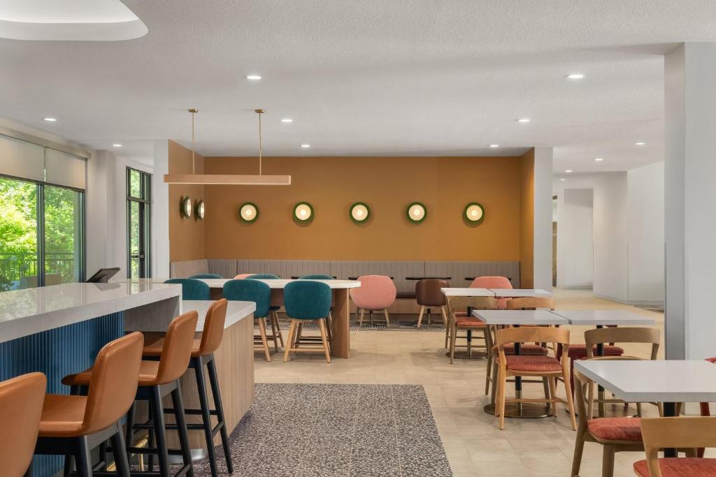 a dining room with tables and chairs at EVEN Hotel Orlando International Airport by IHG in Orlando