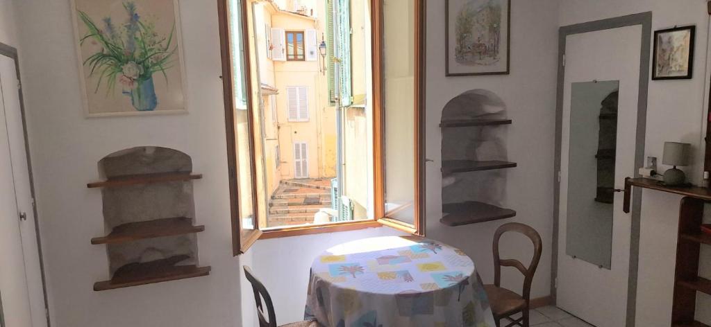 Cette chambre dispose d'une table et d'une fenêtre. dans l'établissement PROMO! Studio, Plein Center, Vieux Port, 200 m des plages, à Cannes