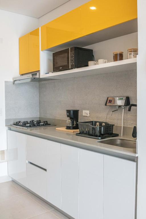 a kitchen with white counters and yellow cabinets at Salinas del Mar Suite in Santa Marta