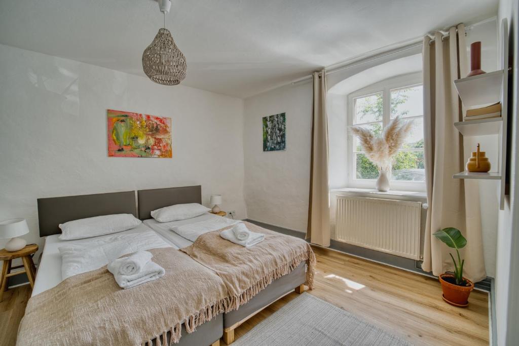 a bedroom with a bed with towels on it at Suite Kelnhof Patio - Cozy Riverside Apartment in Küssaberg