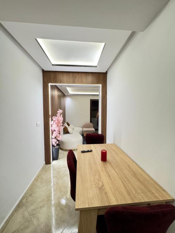 Un comedor con mesa y sillas de madera. en Résidence Redouan, en Tánger