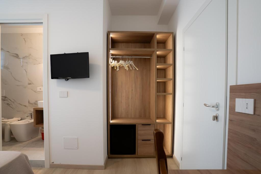 a room with a closet with a tv in it at Hotel Berna in Eraclea Mare