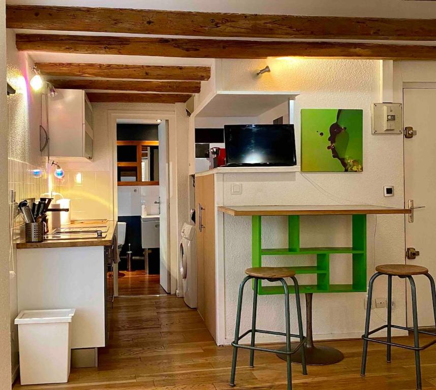 - une petite cuisine avec un comptoir et des tabourets dans la chambre dans l'établissement Studio calme - pentes de la croix rousse, à Lyon