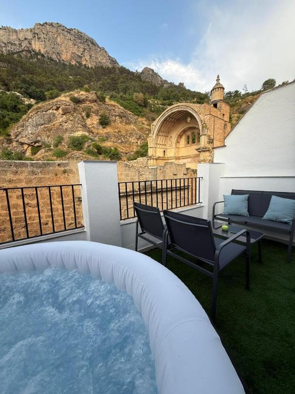 a patio with a hot tub and a table and chairs at Alojamiento Jacuzzi Las Ruinas in Cazorla