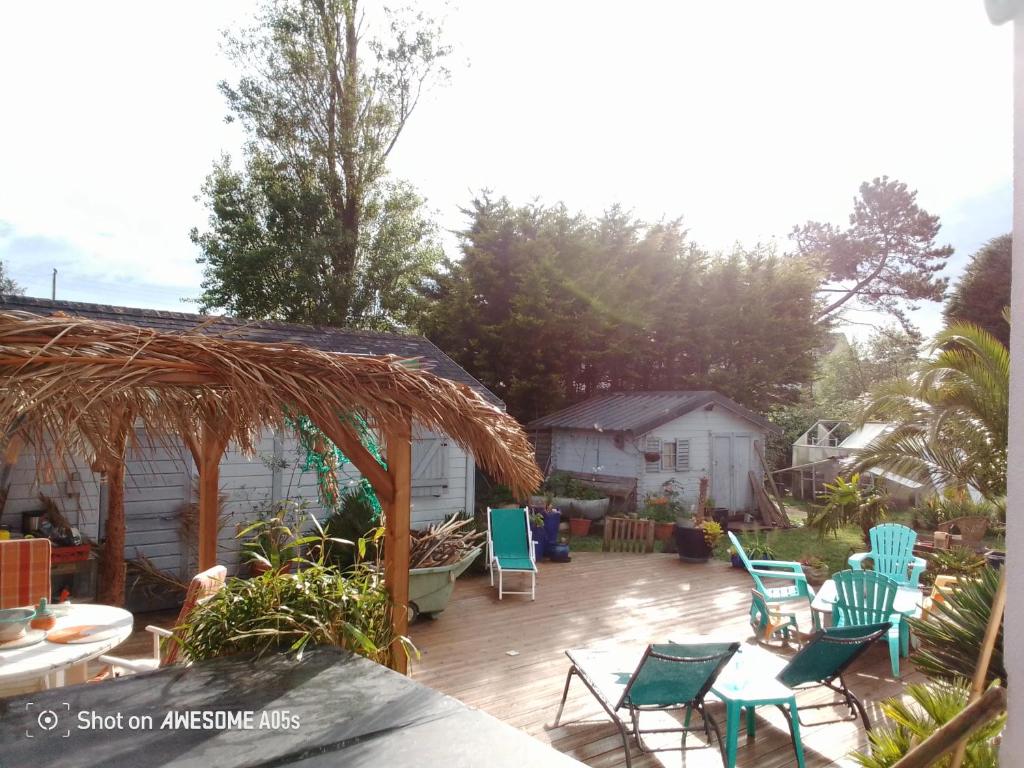 a patio with lawn chairs and a gazebo at D'Ici ou D'ailleurs in Barneville-Carteret