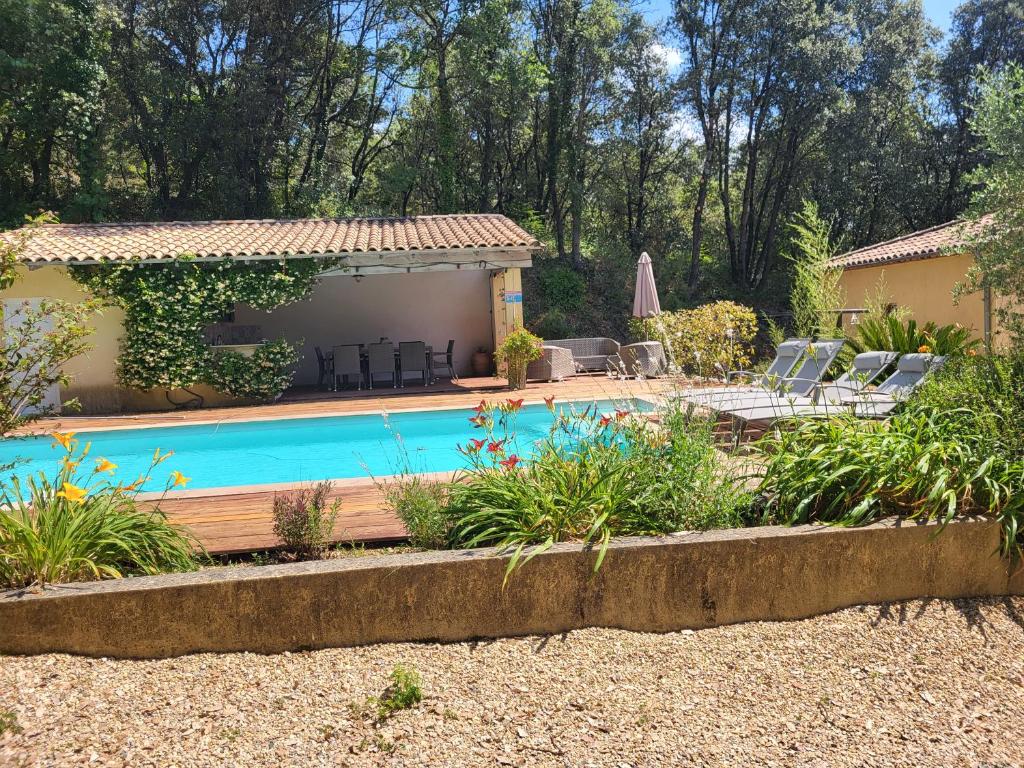 a pool in a yard with chairs and a house at L'ostal de la Patz in Saint-Julien-de-la-Nef
