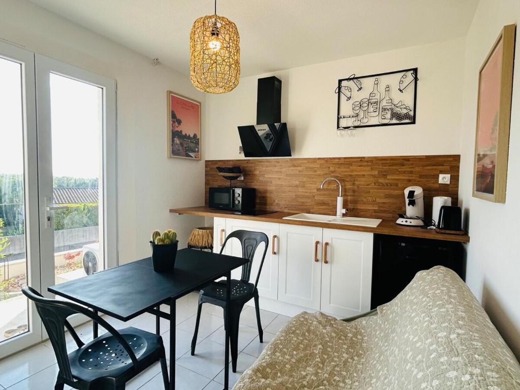 une cuisine avec une table, des chaises et un évier dans l'établissement Escapade à Carcassonne, à Carcassonne