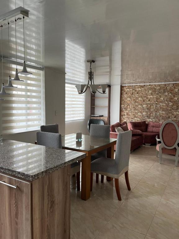 a kitchen and living room with a wooden table and chairs at Apartamento familiar en el centro de Pereira in Pereira