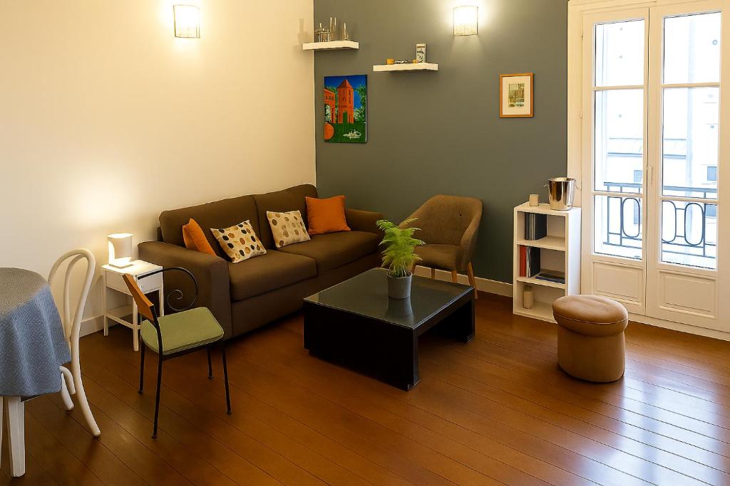un salon avec un canapé et une table dans l'établissement Sunny Serenity: 2-room Charm in Boulogne, à Boulogne-Billancourt