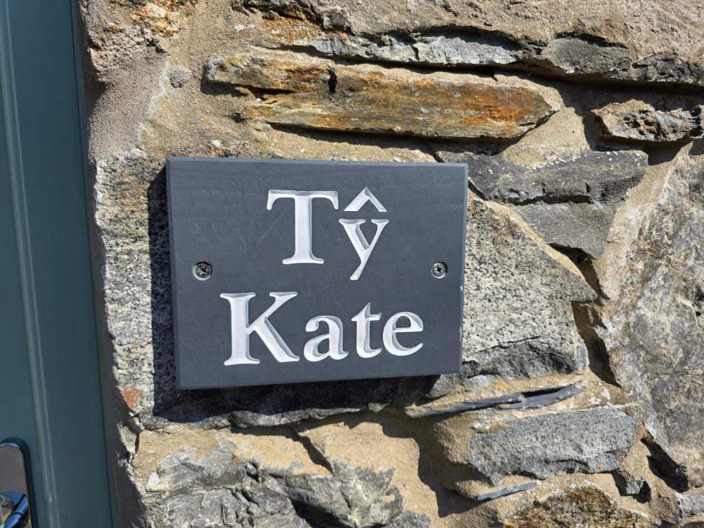 ein Schild an der Seite einer Steinmauer in der Unterkunft Pet friendly two bedroom cosy cottage in Tanygrisiau
