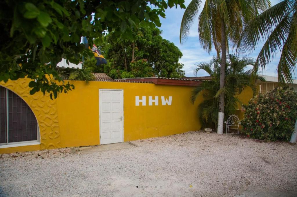 a yellow wall with the word hm painted on it at Simple Studio at Studenthouse Casa Caia in Willemstad