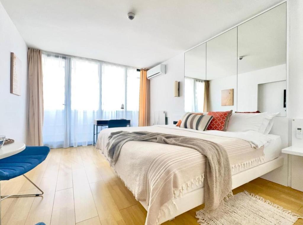 a bedroom with a large white bed with a large mirror at BATUMI ORBI APARTMENTs in Angisa