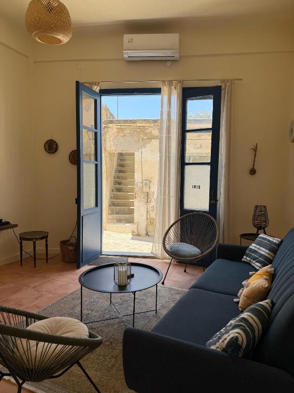 a living room with a blue couch and a table at iris house in Kalo Chorio