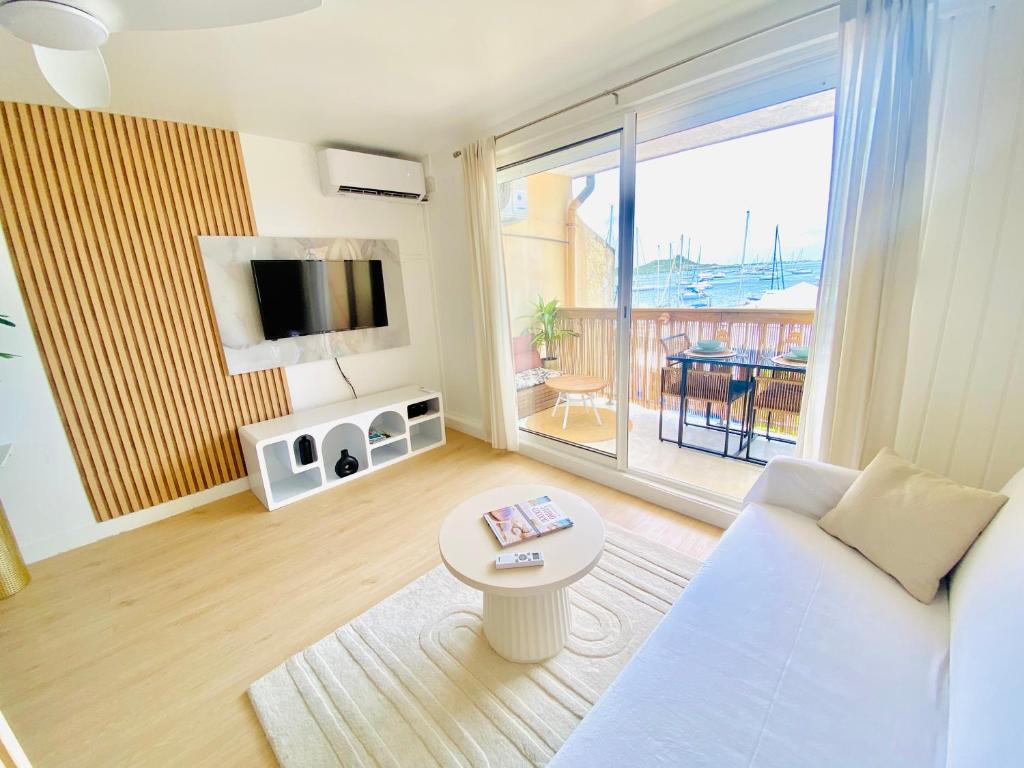 a living room with a white couch and a table at Studi0 coco0n, vue sur la marina in Marigot