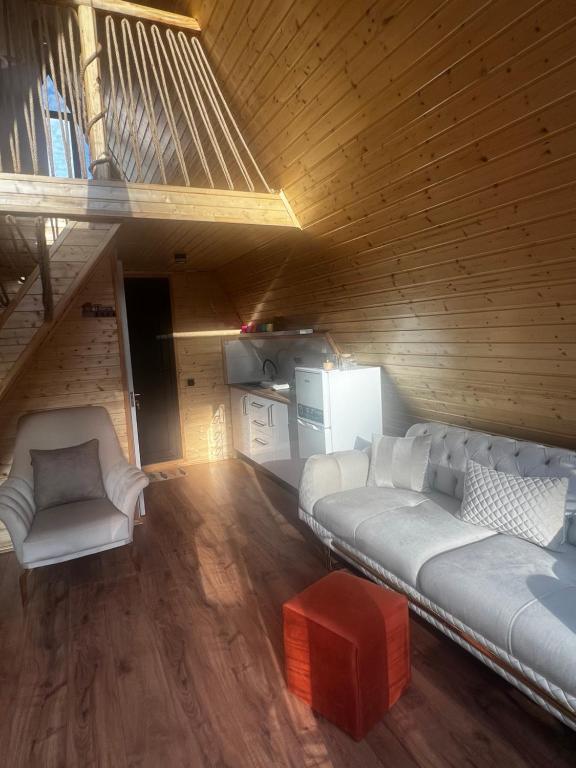 sala de estar con sofá blanco y escaleras en Sweet Cottage, en Kobuleti
