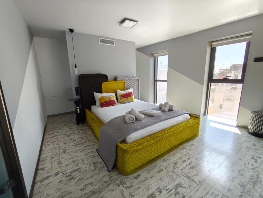 a bedroom with a yellow bed with stuffed animals on it at Athina Art Apartments in Athens