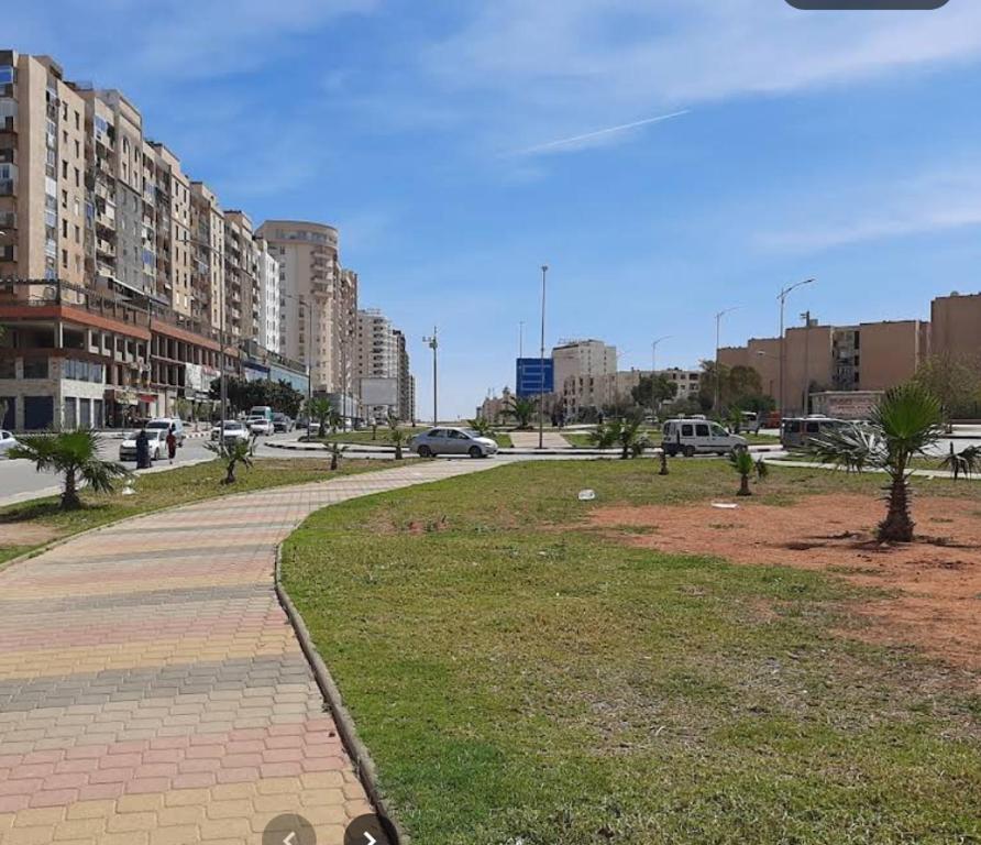 a park in a city with buildings and a street at Residential Apartment in Bir el Djir
