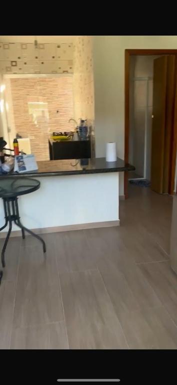 a kitchen with a white counter and a table at Casa Temporada Itanhaém Portaria 24h in Itanhaém