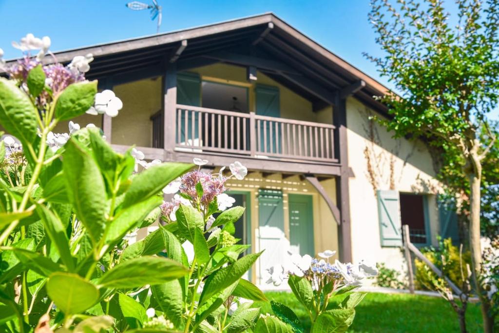 a house with a balcony and some plants at Maison familiale au vert avec piscine et pétanque in Biaudos