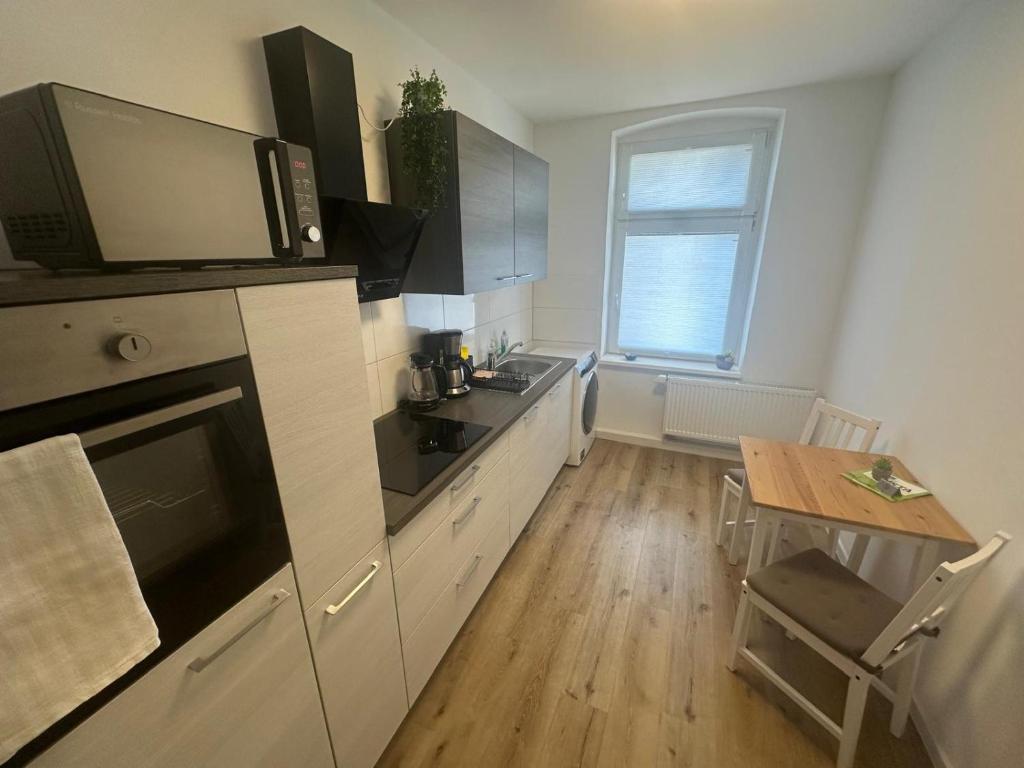 a small kitchen with a table and a microwave at Wohlfühl-Oase in Herne