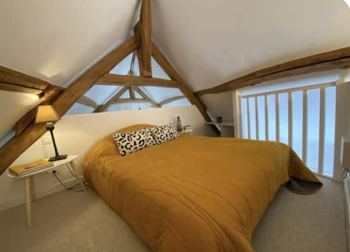 une chambre avec un lit dans une pièce avec une fenêtre dans l'établissement La Biche, à La Celle-sous-Gouzon