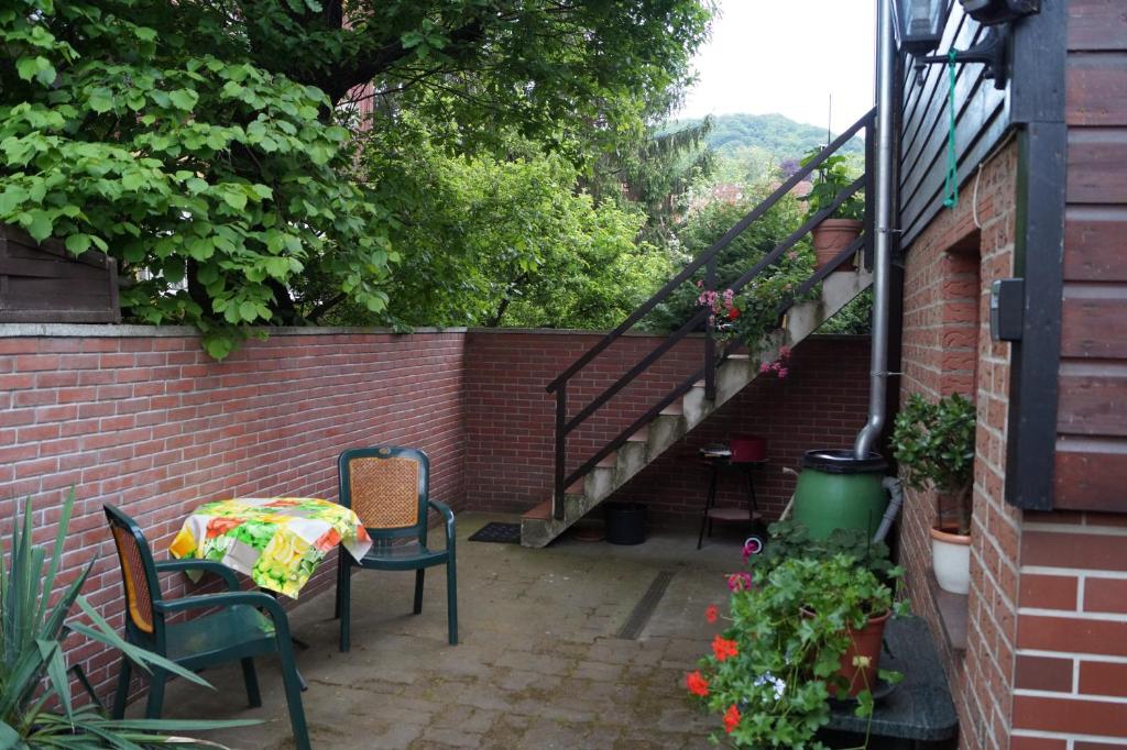 eine Terrasse mit einem Tisch, Stühlen und Treppen in der Unterkunft FeWo Carmen in Wernigerode