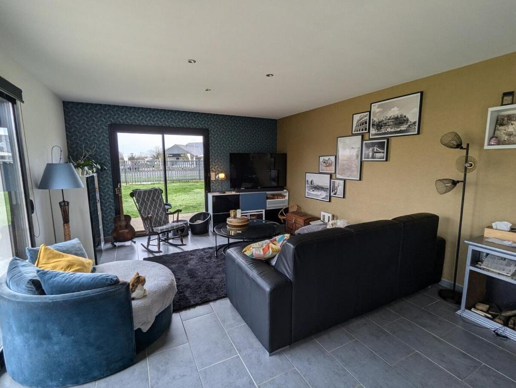 un salon avec deux canapés et une télévision dans l'établissement Maison de famille, 5min des plages, à Saint-Alban