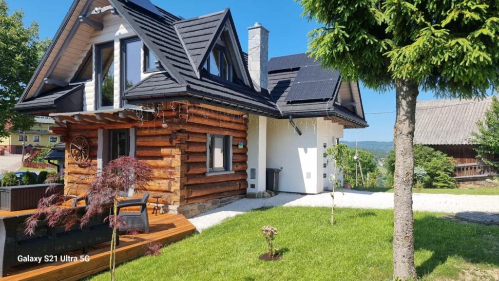a log house with a gambrel roof at Domek U Babci in Istebna