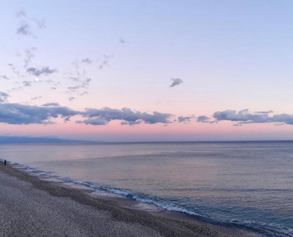 a beach with a person standing on the shore at Sulla spiaggia di Letojanni in Letojanni