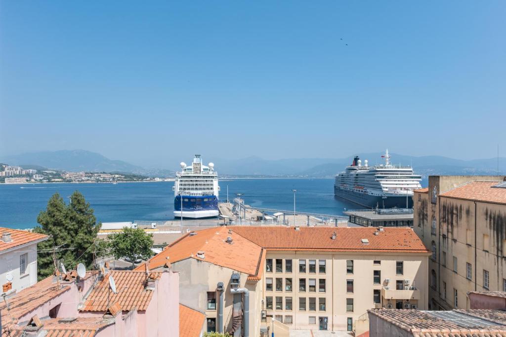 deux navires de croisière amarrés dans un port avec des bâtiments dans l'établissement T2 40m2 climatisé centre ville FESCH, à Ajaccio