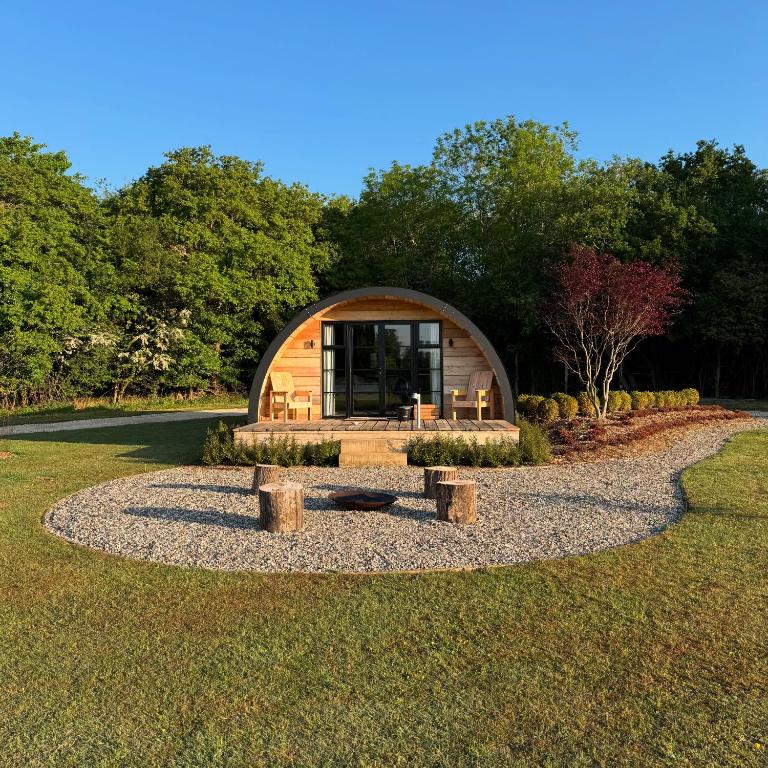 a circular cabin in the middle of a park with trees at The Goose In The Woods - With Lakeside Sauna in Wellesbourne Hastings